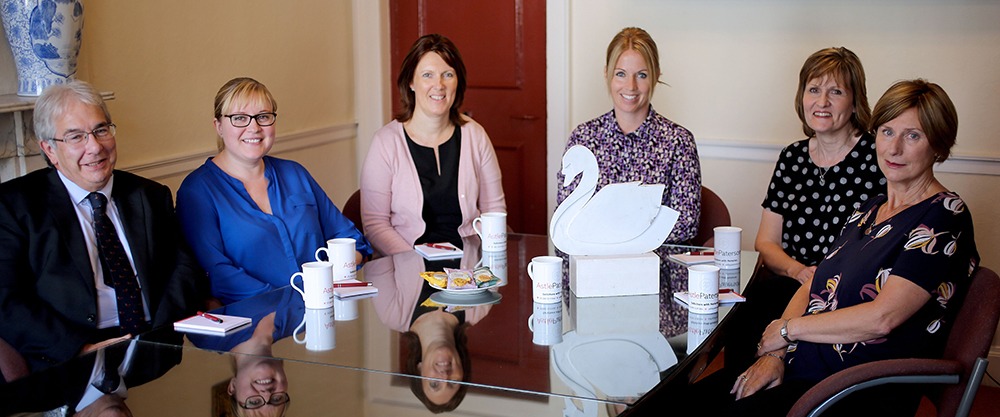 Members of the Astle Paterson team with a miniature swan sculpture. 