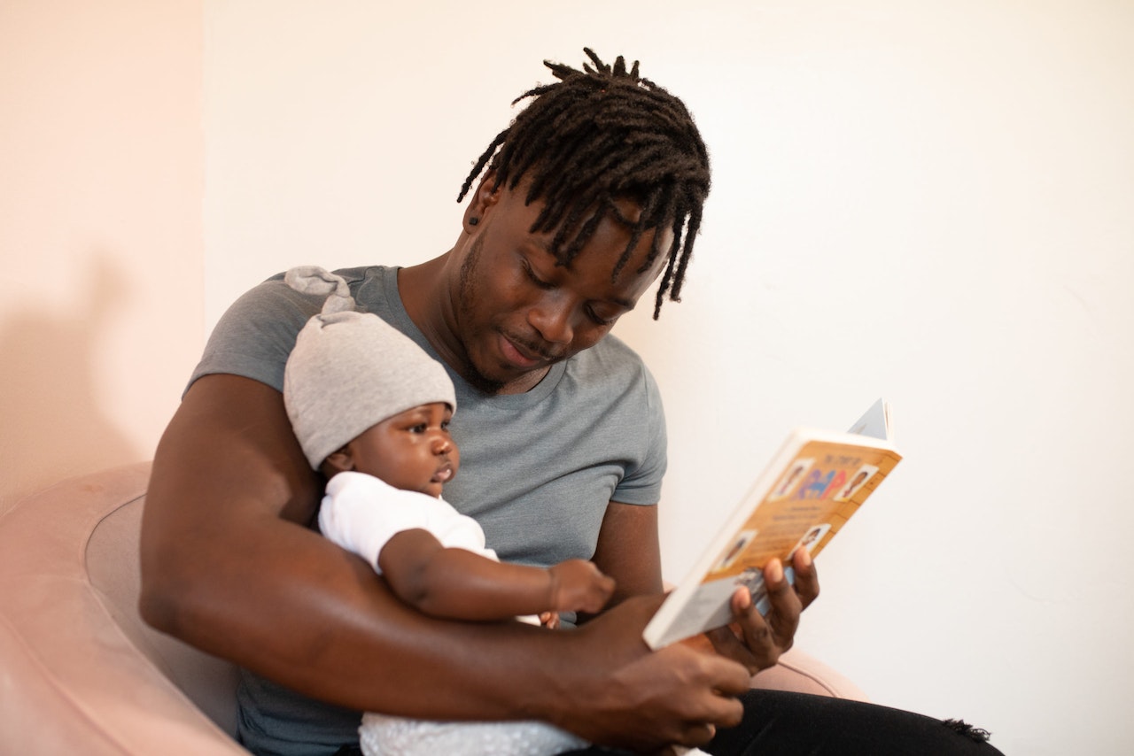 Man in Grey Shirt holding his infant child wanting to choose a Child Arrangement Lawyer