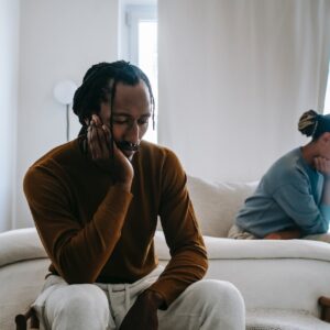Couple sitting apart after just arguing about the cost-of-living crisis effecting their finances