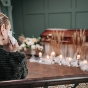 A Woman Sitting on a Chair At A Funeral Representing Debt Of Deceased Spouse, spouse debt after death