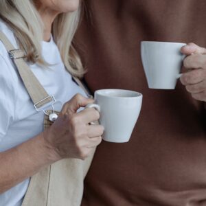 An elderly couple drinking mugs of tea as they take a break from creating their will and dealing out their inheritance