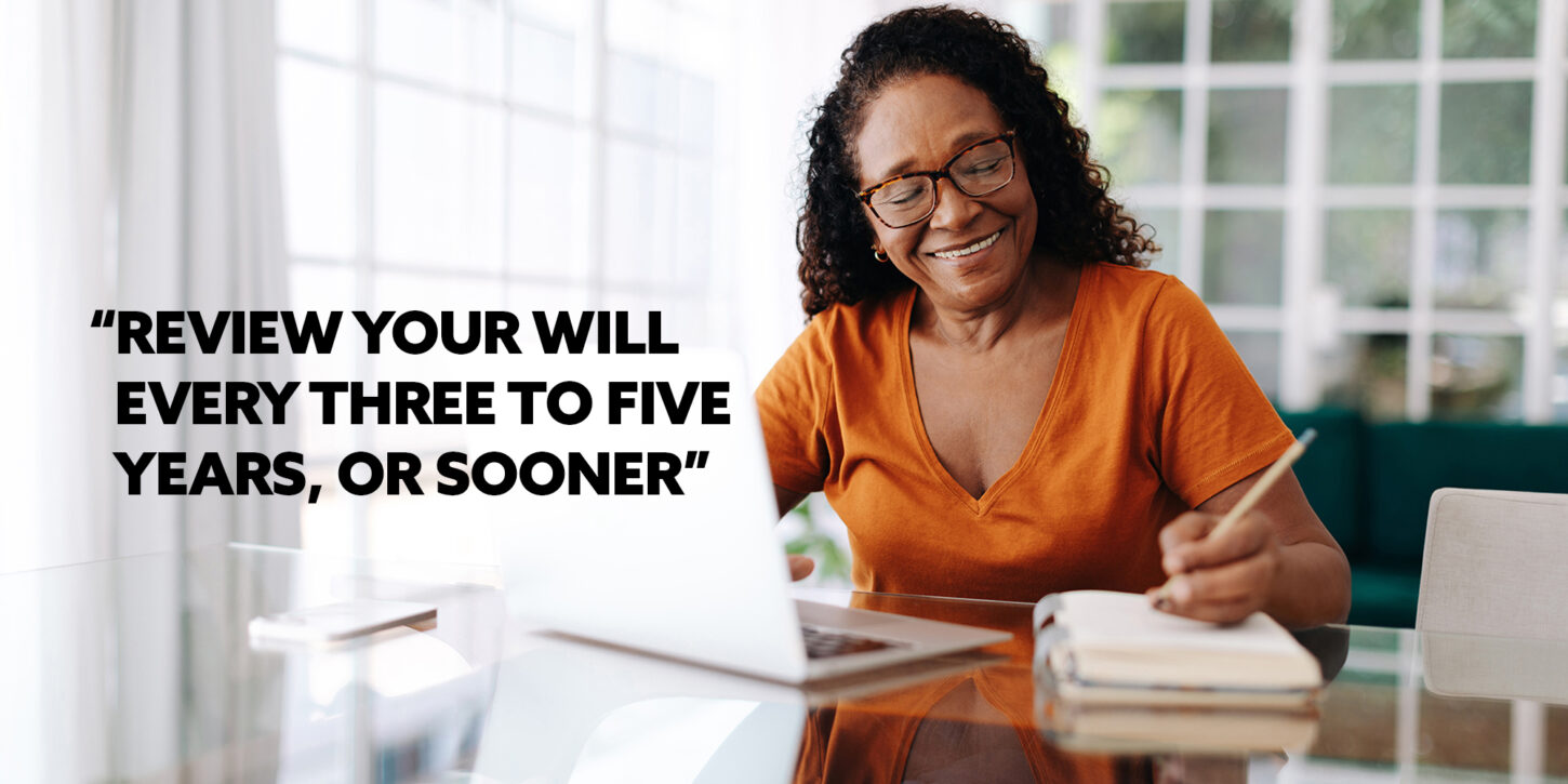 Why Wills, Probate and Trusts matter for you and your family 2 Woman sitting at the table with a laptop, writing on a notebook, and there is writing that says "Review your will every three to five years, or sooner"